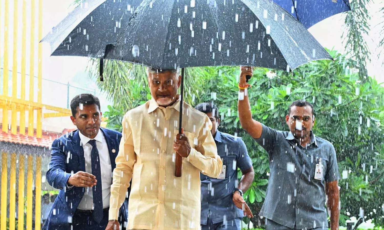 CM Chandrababu Walks Through Rain, Carries Umbrella During TDP Meet